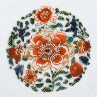 圖為清代五彩花卉紋碟細(xì)節(jié)圖，碟心主題紋飾為團(tuán)花圖，紅花綠葉，相映成趣。（來源：廣州十三行博物館）