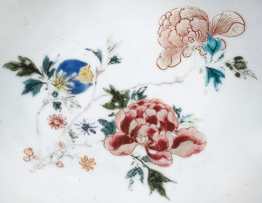 圖為清中期粉彩花卉紋剃須盤(pán)細(xì)節(jié)圖，盤(pán)心主題紋飾為花卉圖。（來(lái)源：廣州十三行博物館）